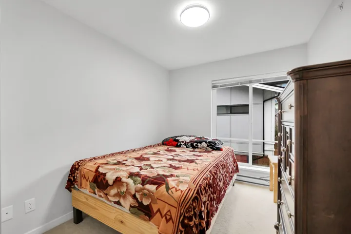 Bedroom featuring light carpet and baseboards