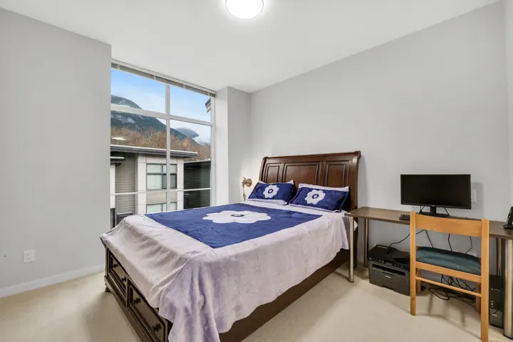 Bedroom with light colored carpet and an office area