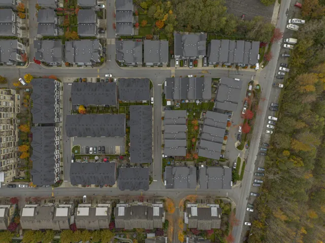Aerial view of property and surrounding area with nearby suburban area
