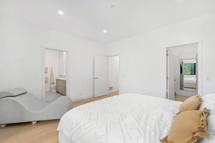 Bedroom with ensuite bath, light wood-style flooring, and recessed lighting