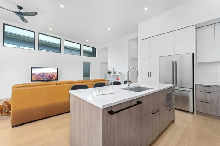 Kitchen with modern cabinets, stainless steel appliances, recessed lighting, light wood finished floors, and decorative backsplash