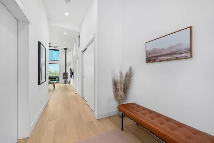 Hall with light wood-style floors, recessed lighting, and a high ceiling