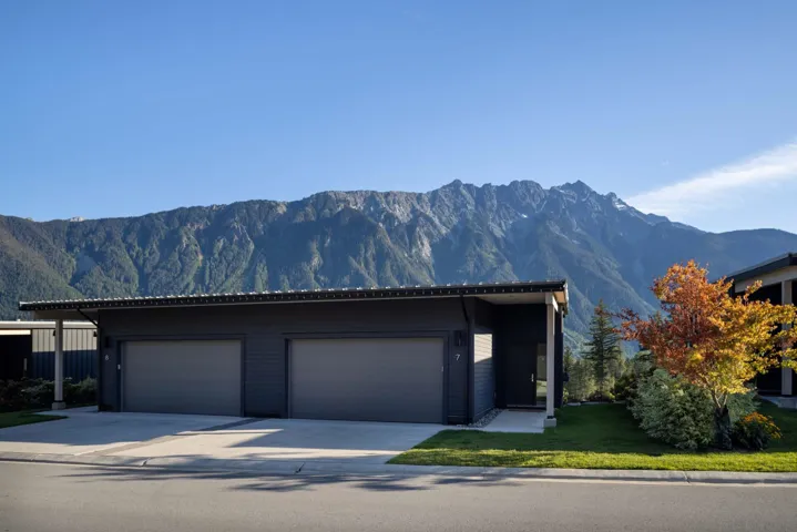 View of front facade featuring concrete driveway, a mountain view, an attached garage, and a front yard