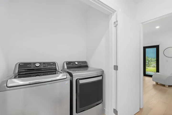 Laundry room featuring wood finished floors, independent washer and dryer, and recessed lighting