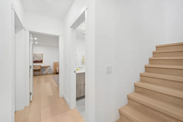 Staircase featuring wood finished floors and recessed lighting