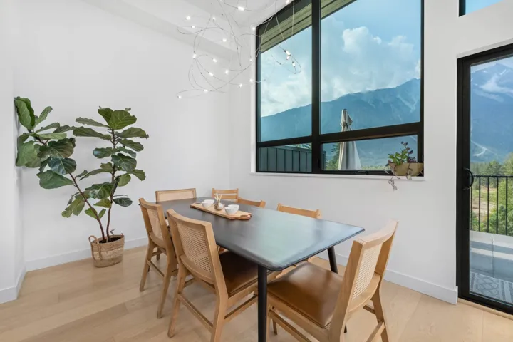 Dining area with a mountain view, light wood-style flooring, and plenty of natural light