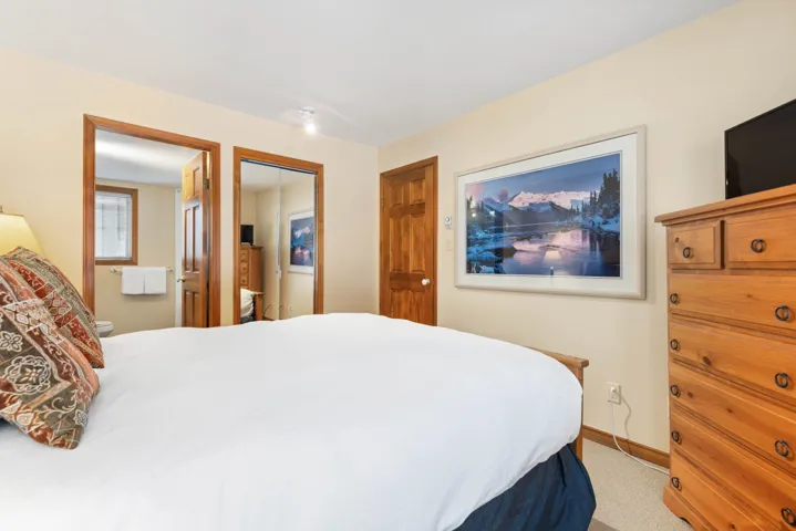 Bedroom featuring light colored carpet, a closet, and baseboards