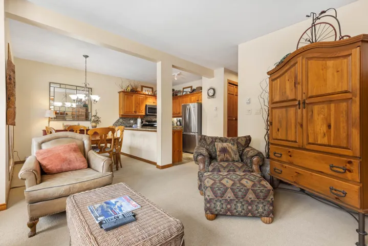 Living area with an inviting chandelier and light carpet