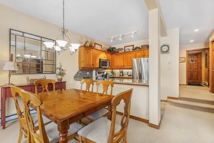 Dining space featuring baseboards, a chandelier, recessed lighting, and light colored carpet