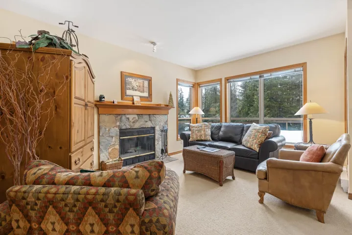Living area with a premium fireplace and light colored carpet