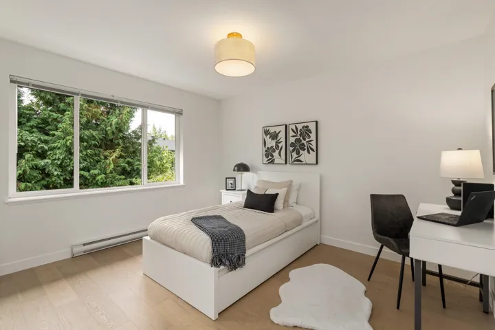 Bedroom featuring a baseboard heating unit and wood finished floors