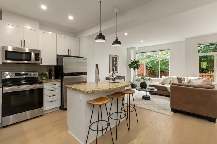 Kitchen with stainless steel appliances, a breakfast bar, tasteful backsplash, white cabinetry, and recessed lighting