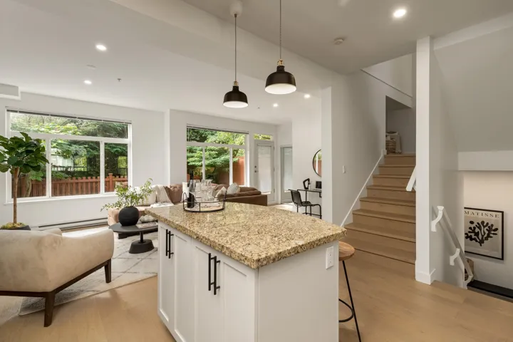 Kitchen featuring light stone countertops, recessed lighting, white cabinetry, pendant lighting, and light wood-style floors