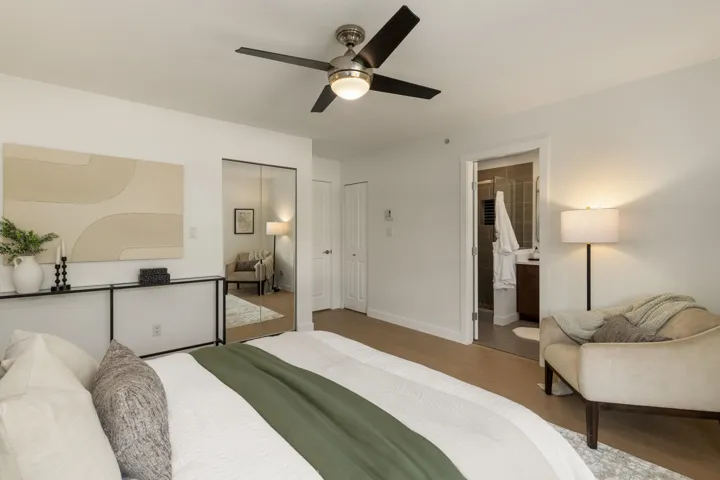 Bedroom featuring wood finished floors, ceiling fan, a closet, and connected bathroom