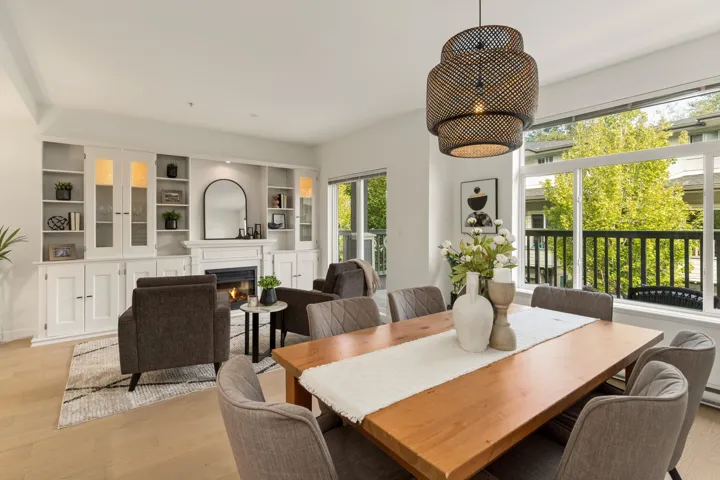 Dining room with light wood finished floors and a lit fireplace