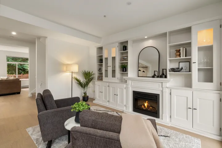 Sitting room featuring light wood-style flooring, a glass covered fireplace, and recessed lighting