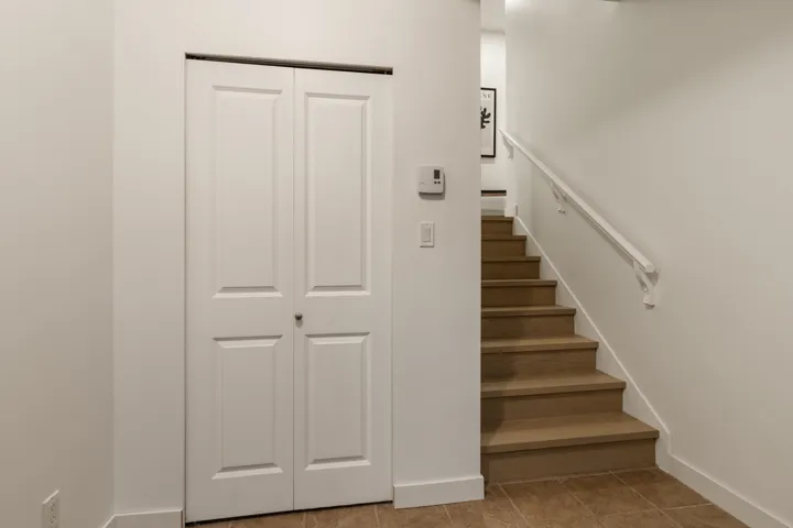 Stairs with tile patterned flooring and baseboards