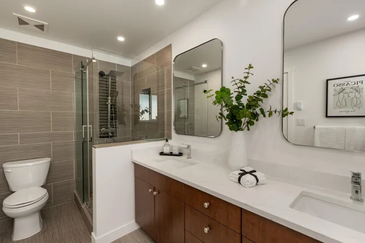 Full bathroom with double vanity, a stall shower, tile walls, and recessed lighting