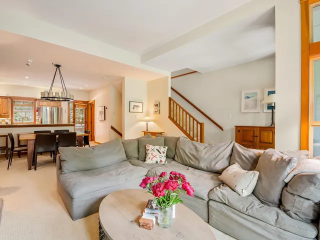 Carpeted living room featuring a chandelier and stairway