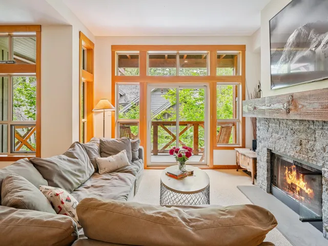 Carpeted living area featuring a fireplace and baseboards