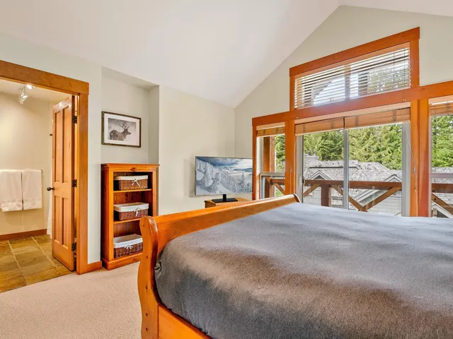 Carpeted bedroom with high vaulted ceiling and ensuite bath