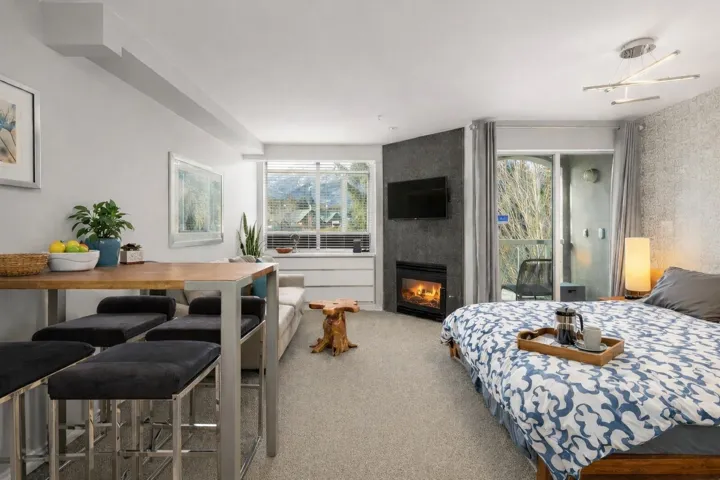 Bedroom with light carpet and a large fireplace