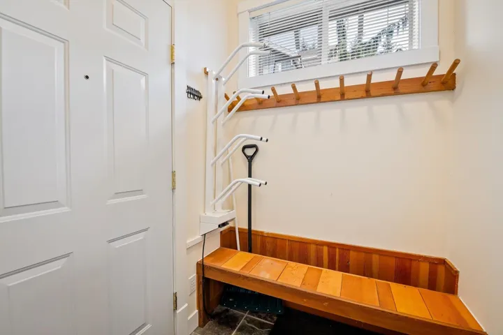 Mudroom with wainscoting and wood walls