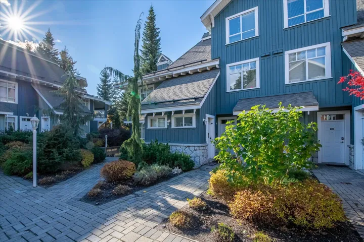 View of front of house featuring board and batten siding, a shingled roof, and stone siding