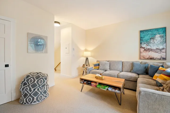 Living area featuring light colored carpet and baseboards