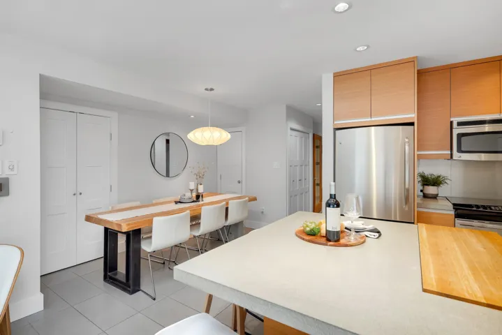 Kitchen featuring stainless steel appliances, light countertops, recessed lighting, light tile patterned floors, and decorative light fixtures