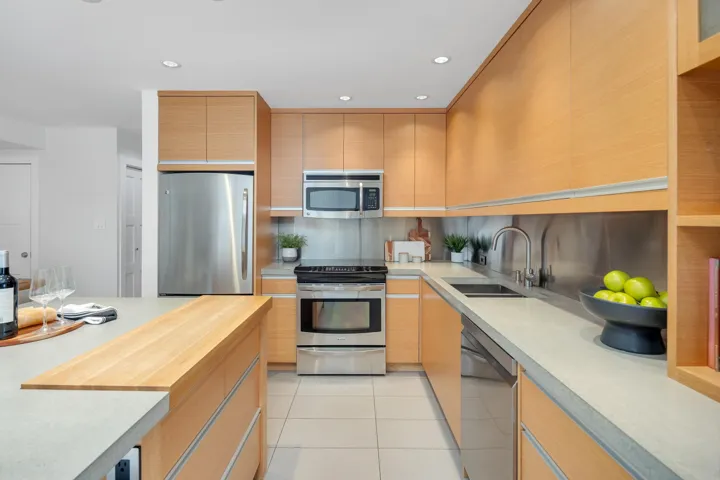 Kitchen with light countertops, stainless steel appliances, recessed lighting, light tile patterned floors, and light brown cabinetry