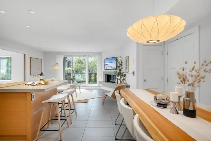Dining area featuring a glass covered fireplace, dark tile patterned flooring, and recessed lighting