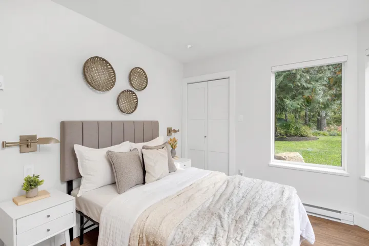 Bedroom with a baseboard heating unit and wood finished floors