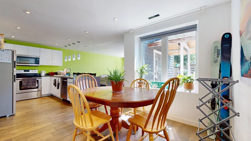 Dining room with light wood finished floors and recessed lighting