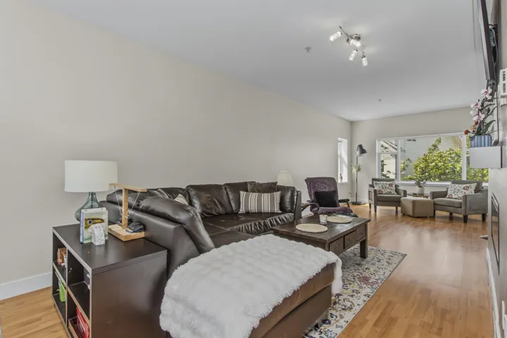 Open-concept living area featuring wood-finish flooring, recessed lighting, and a large picture window