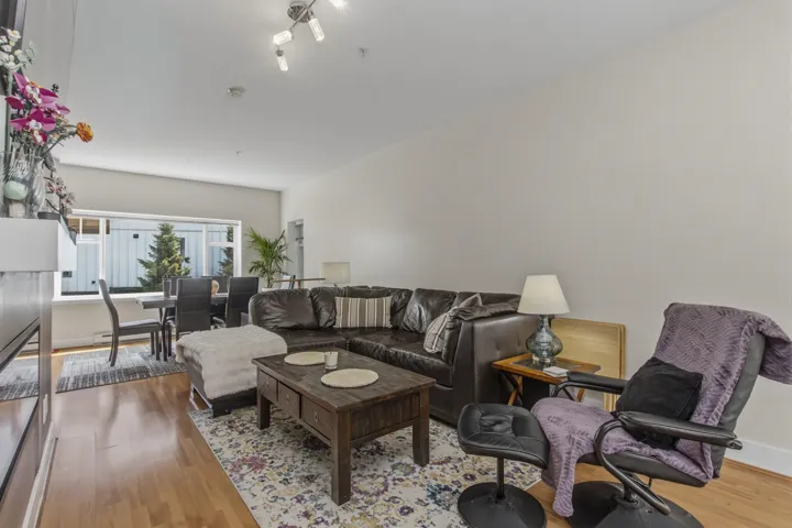 Open-concept living area with wood-finish flooring and track lighting