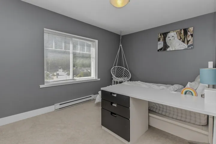 Carpeted room featuring a large window with white blinds, grey painted walls, and white trim
