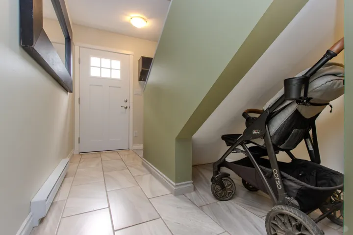 Foyer entrance featuring a baseboard heating unit and light tile patterned floors