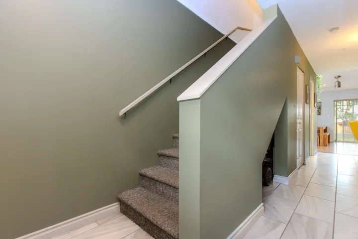 Stairway with baseboards and tile patterned floors