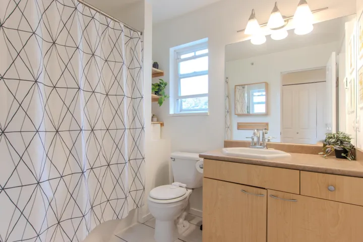 Full bath with vanity, light tile patterned floors, and a shower with curtain