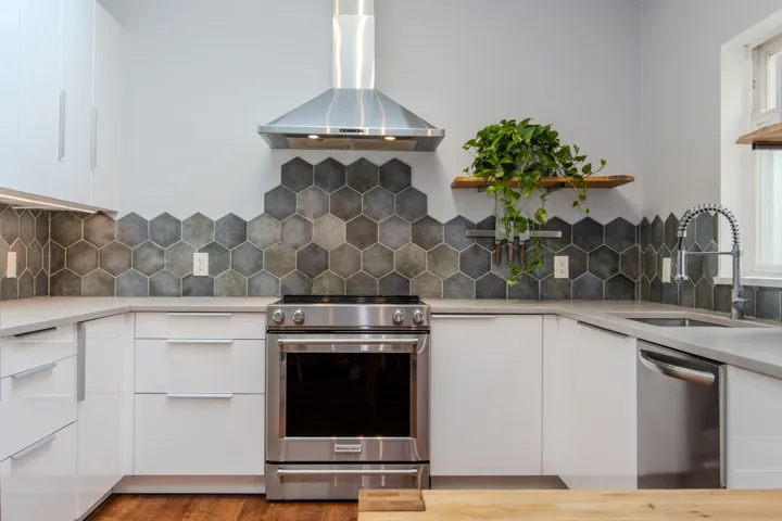 Kitchen with white cabinets, modern cabinets, island range hood, and appliances with stainless steel finishes