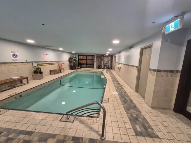 Indoor community pool featuring elevator