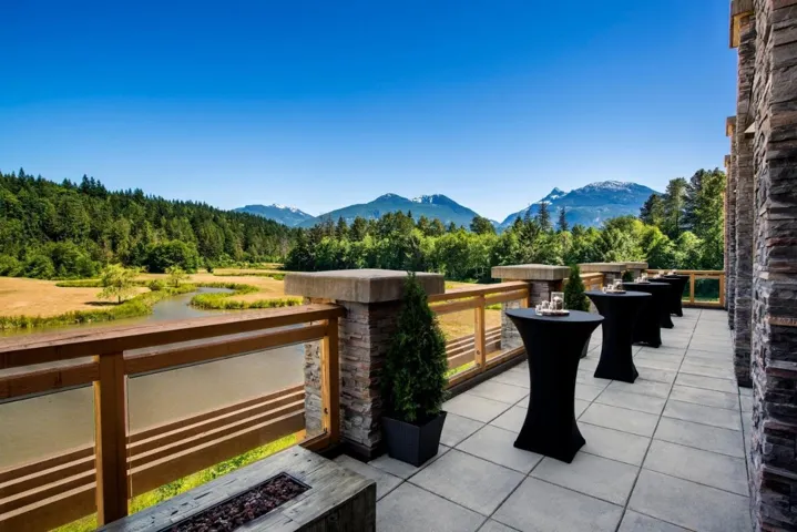View of patio with an outdoor fire pit, a mountain view, a balcony, and a view of trees