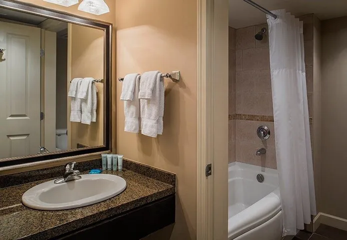 Bathroom with shower / bathtub combination with curtain and vanity