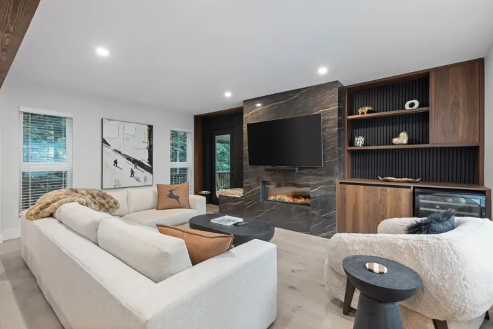 Living room featuring a premium fireplace, healthy amount of natural light, wine cooler, light wood-style floors, and recessed lighting
