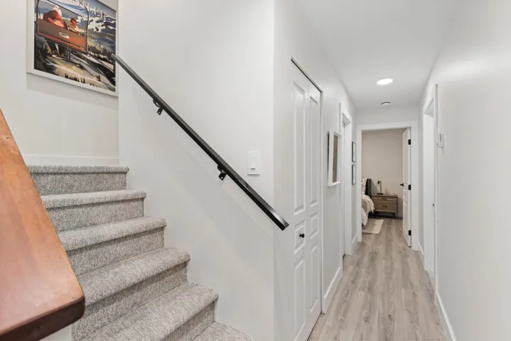 Corridor featuring light wood-type flooring, recessed lighting, and stairway