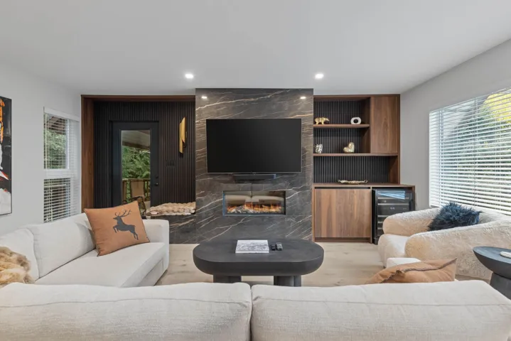 Living room featuring healthy amount of natural light, beverage cooler, light wood finished floors, a premium fireplace, and recessed lighting