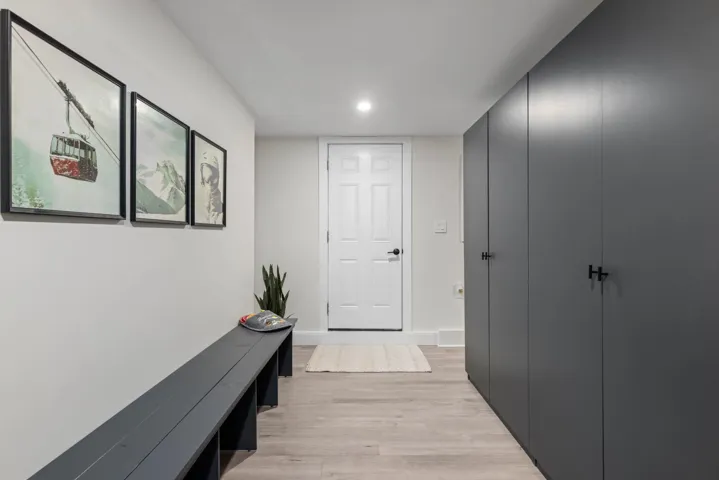 Hallway with light wood finished floors and recessed lighting