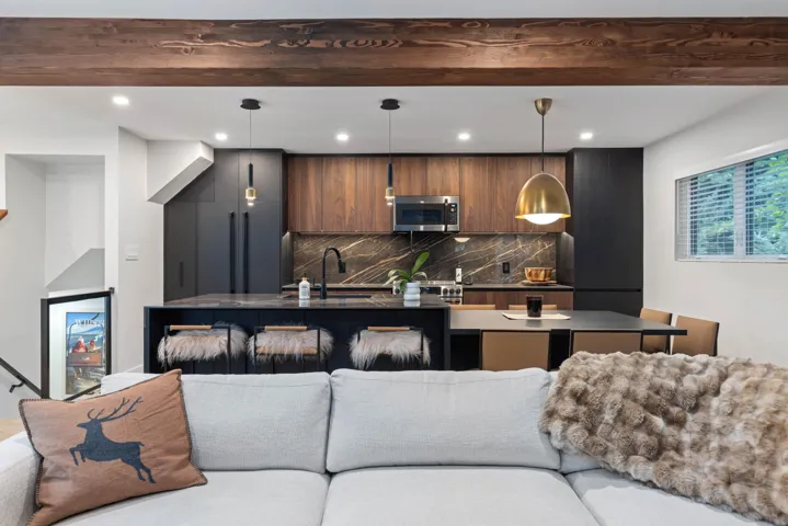 Kitchen with open floor plan, tasteful backsplash, modern cabinets, a center island with sink, and stainless steel microwave