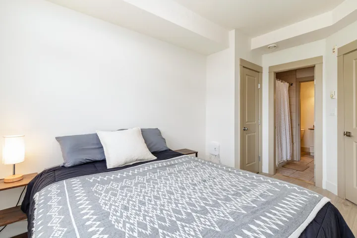 Spacious room featuring light-colored walls and wood-finish flooring